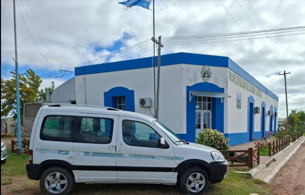 Camioneta municipal estacionada frente a un establecimiento educativo en Colonia Libertad, Corrientes.