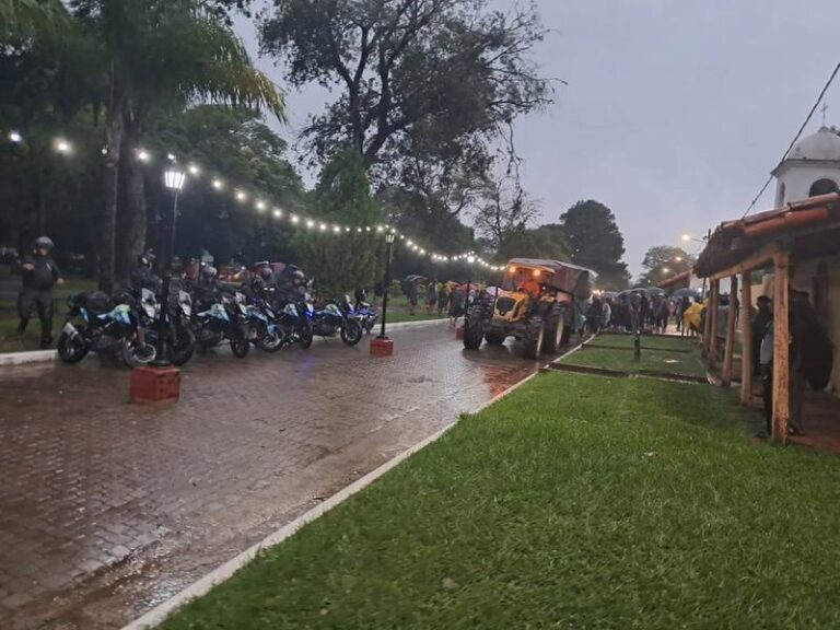 Peregrinos avanzando por un camino rural bajo la lluvia durante la Peregrinación de los Tres Pueblos en Corrientes.